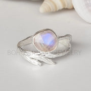 Silver ring with a moonstone on a light gray background